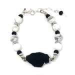 Black, white, gray, and silver "Lake Moon" bracelet from STARSNOW Collection, featuring black tourmaline focal and white howlite beads, on a white background